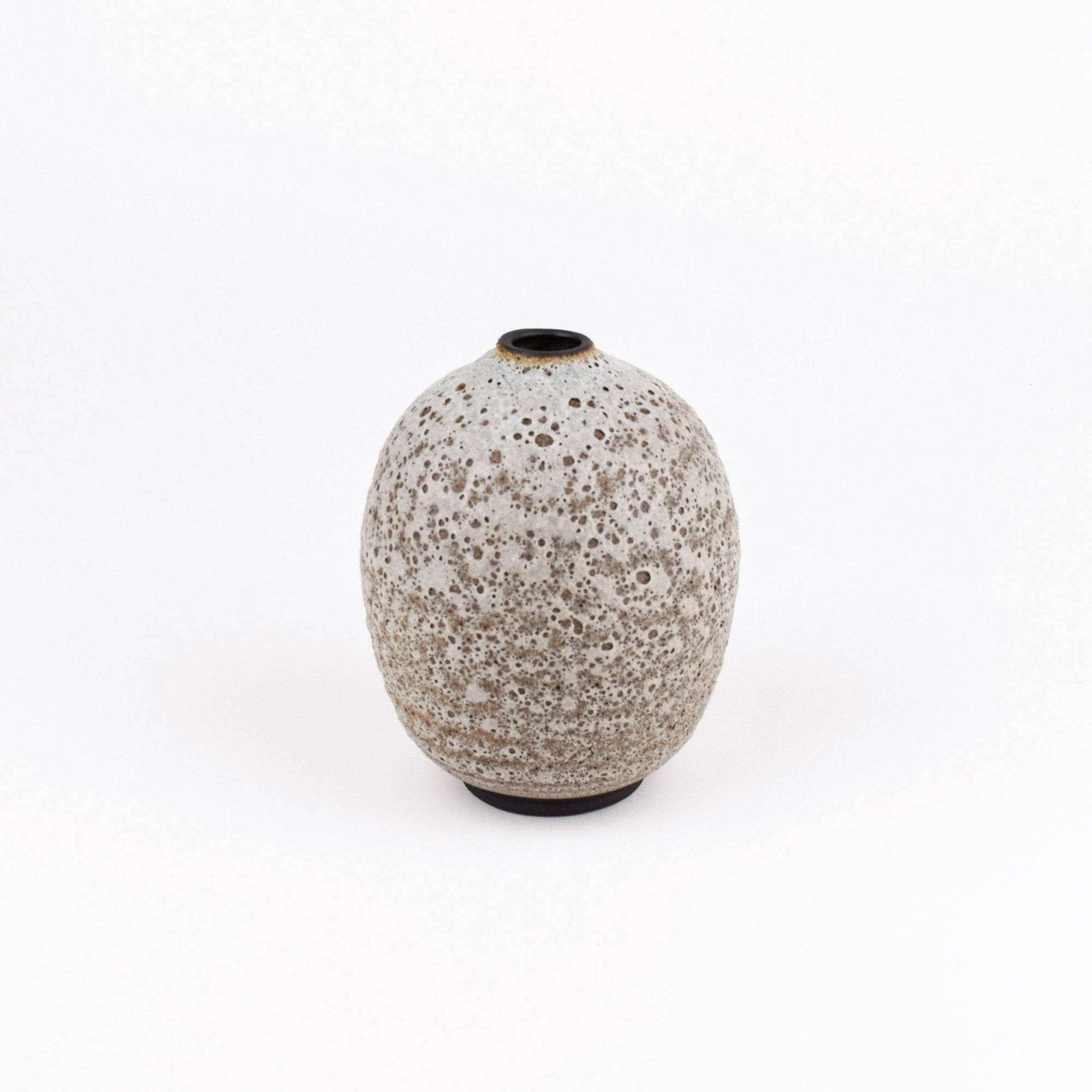 A small ceramic vase with a rounded, bulbous shape and a speckled glaze in warm beige and gray tones, set against a plain white background.
