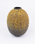 An oval-shaped ceramic vase with a textured, speckled glaze transitioning from a warm mustard yellow at the top to a dark charcoal gray blue at the bottom, set against a plain white background.