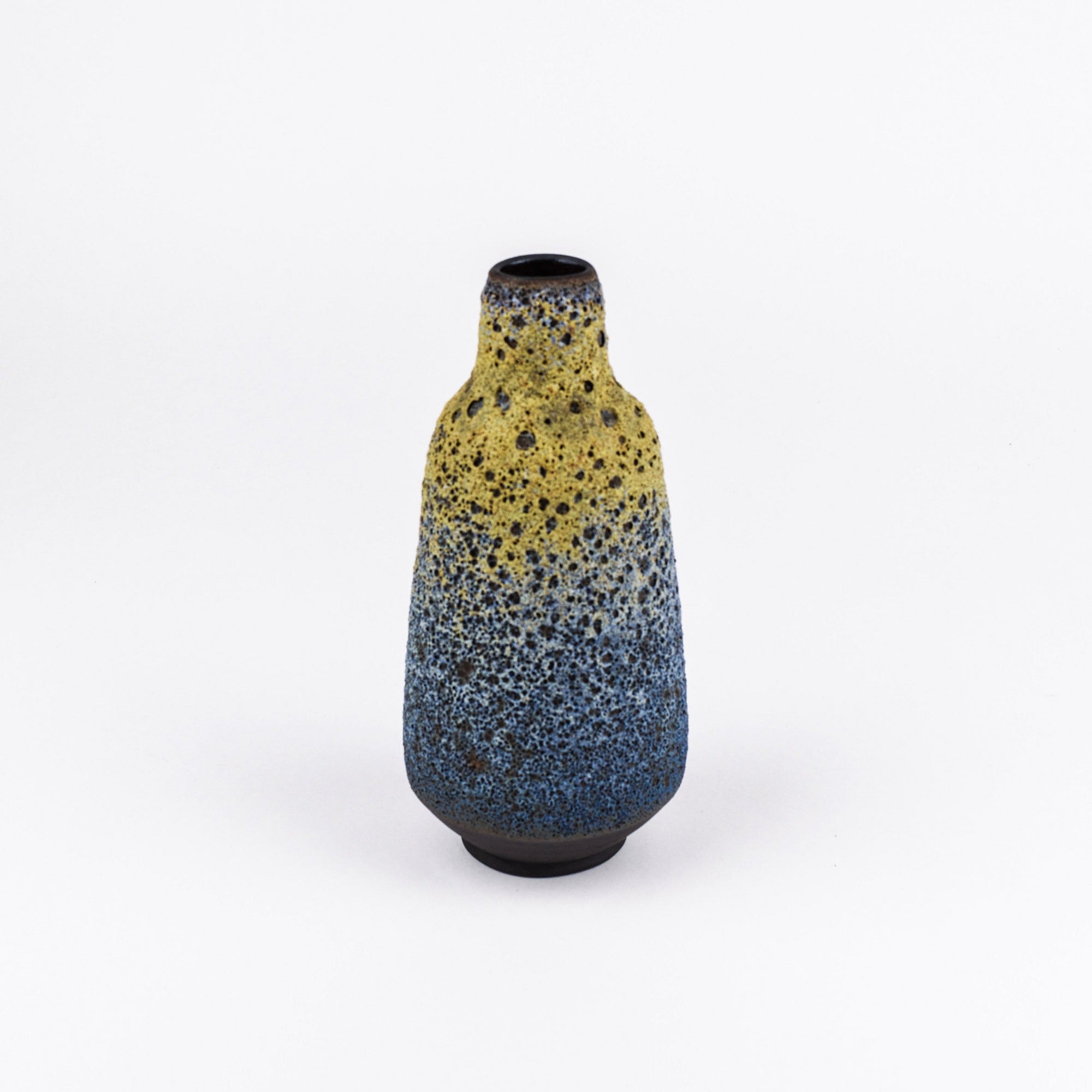A small ceramic bottle vase with a yellow-to-blue speckled glaze, standing on a white background.