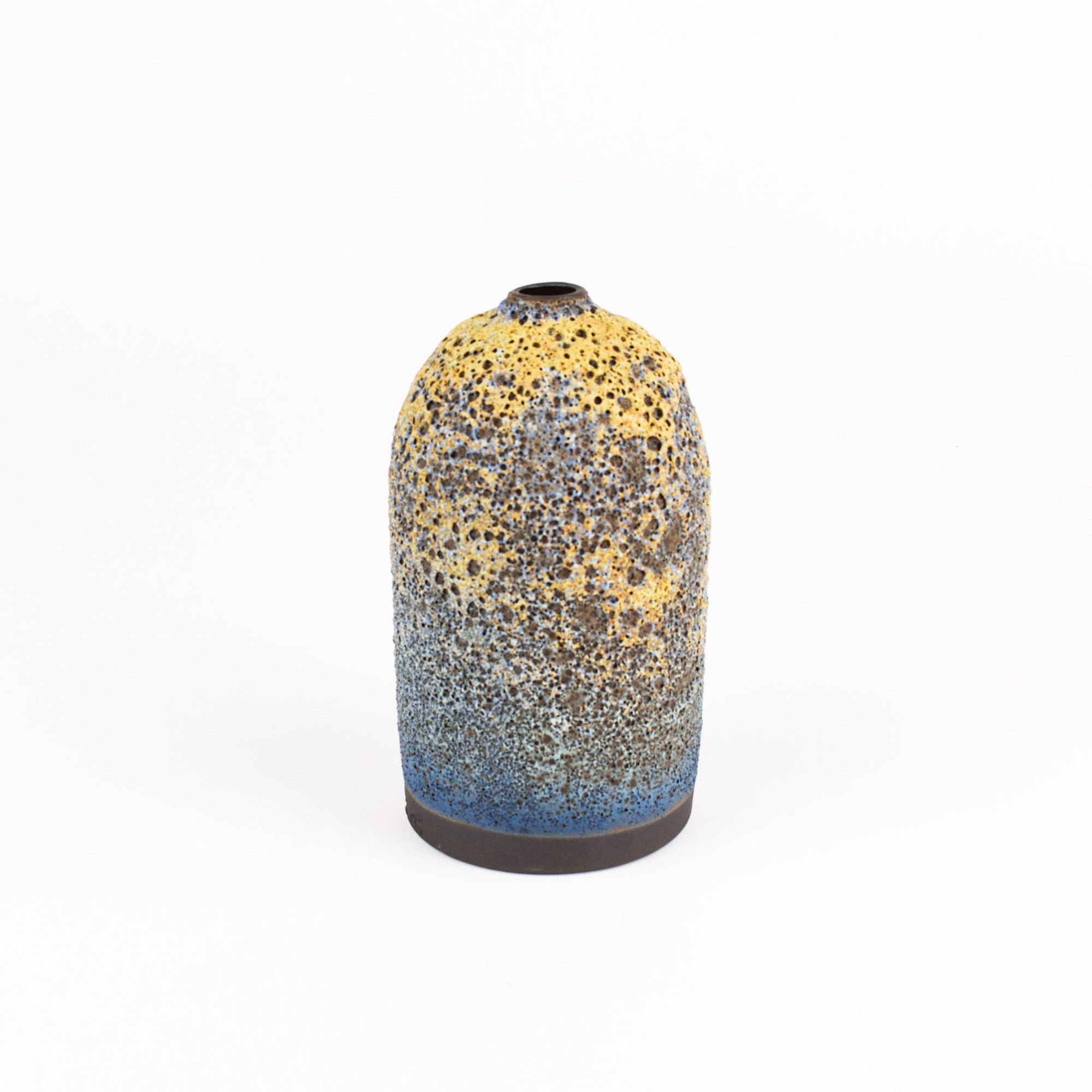 A small ceramic vase with a rounded body, featuring a speckled glaze that transitions from yellow and gray at the top to blue at the base, set against a plain white background.
