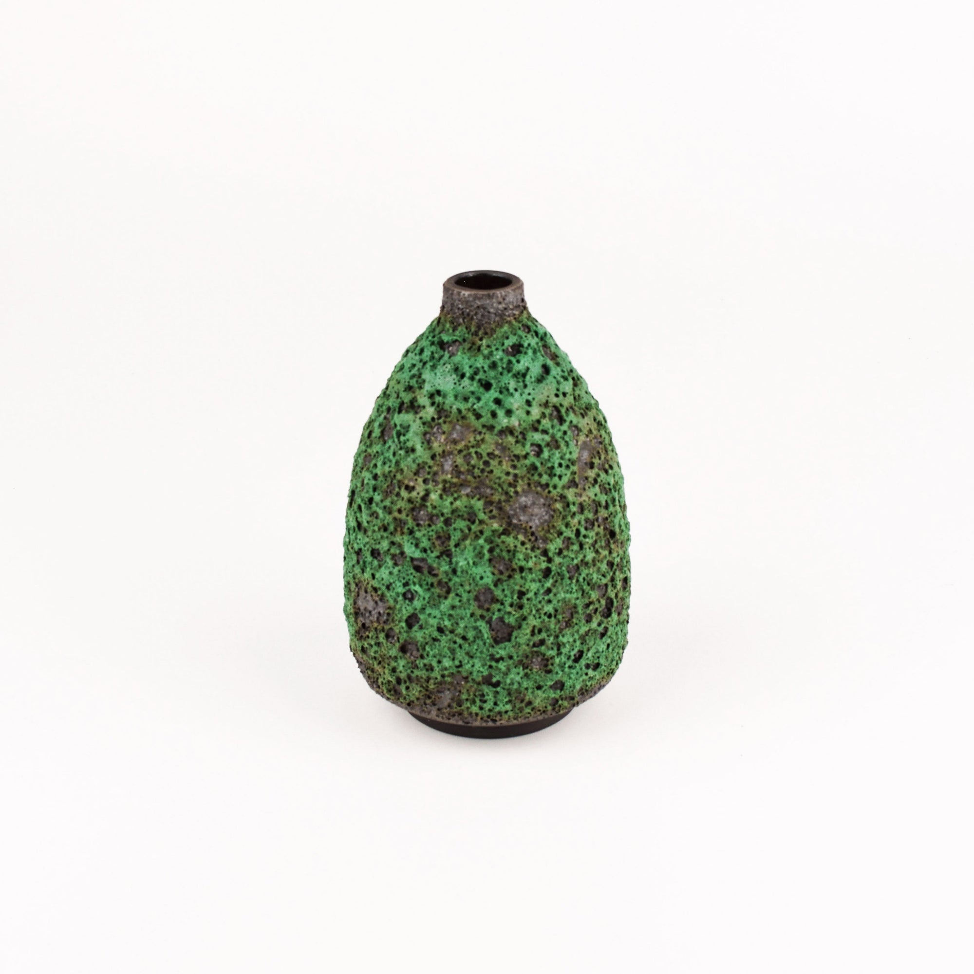 A small textured ceramic vase with a rounded body, narrow neck, and dark base, decorated with a mottled green and brown speckled glaze, set against a plain white background.