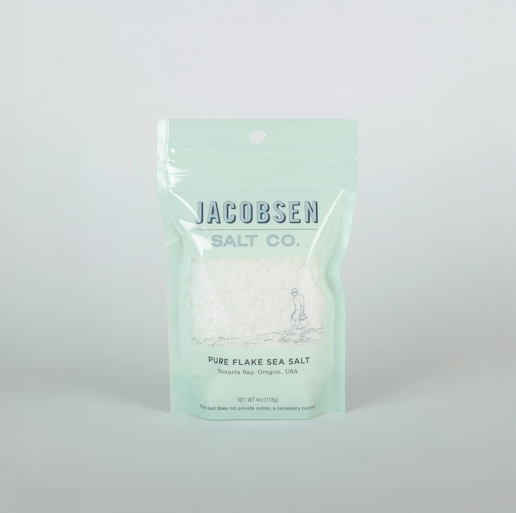 Packaging of Jacobsen Salt Co. pure flake sea salt on a light gray background
