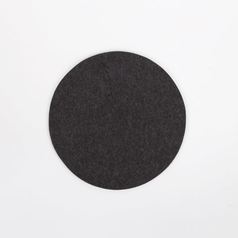 Round black felt coaster on a white background
