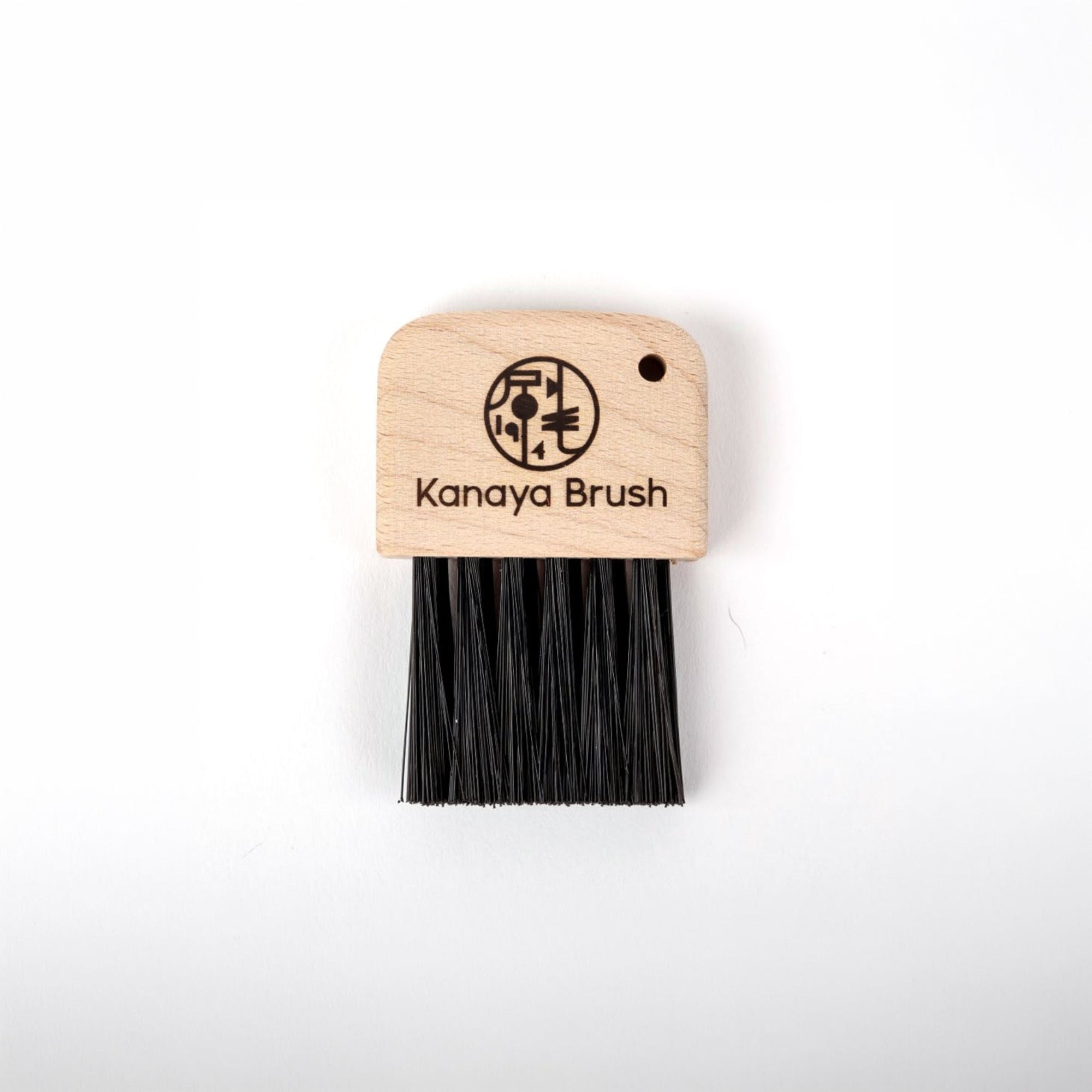 Keyboard brush with wooden handle and black bristles on a white background