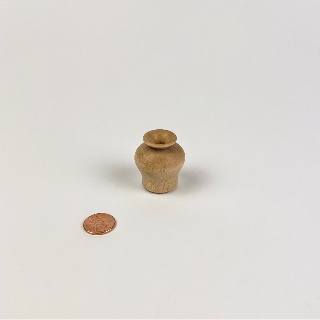 Small wooden vase on a white background with a coin for scale
