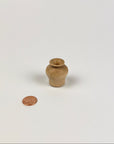 Small wooden vase on a white background with a coin for scale