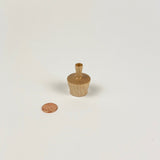 Small wooden vase next to a penny on a white background