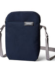 Navy blue crossbody bag with gray strap on a white background