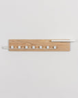 Wooden wall shelf with white accents on a light gray background