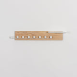 Wooden wall shelf with white accents on a light gray background