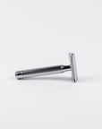 Chrome safety razor with a textured handle on a white background