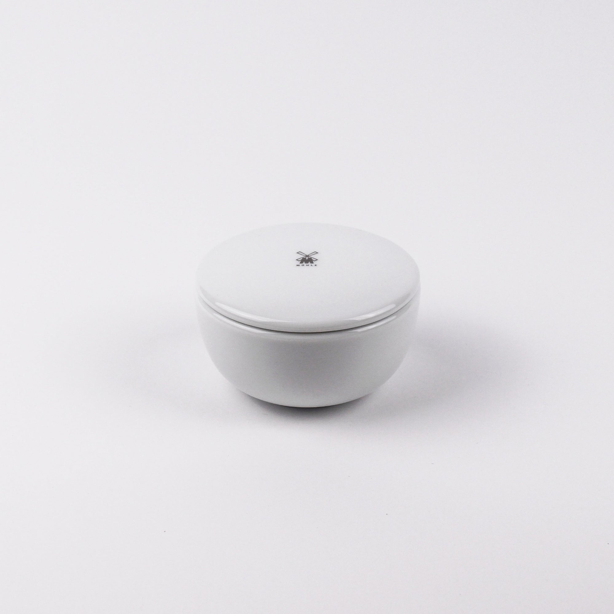 White ceramic bowl with a lid on a white background