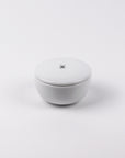 White ceramic bowl with a lid on a white background