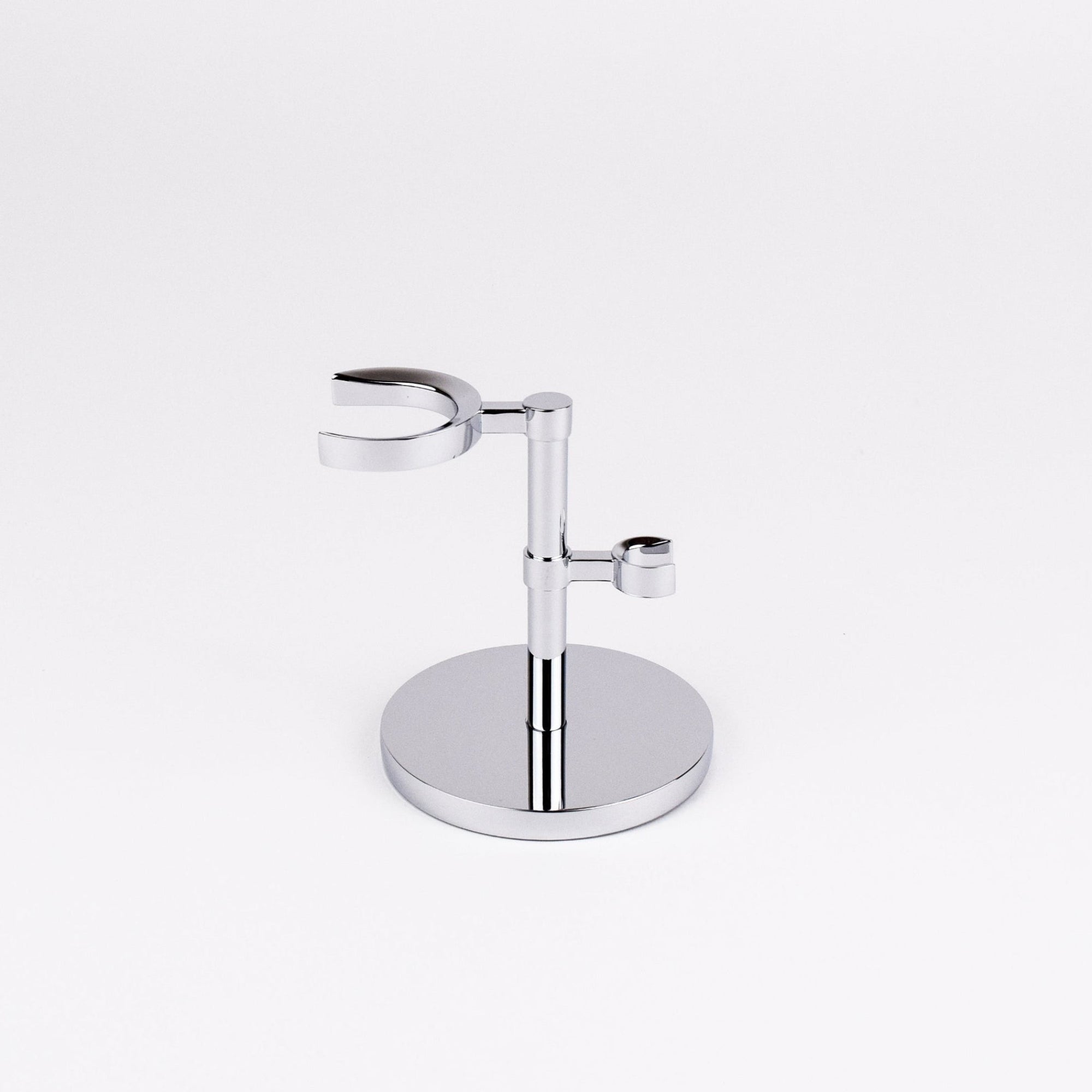 Chrome razor and shaving brush holder on a white background