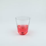 Clear glass with red liquid on a white background
