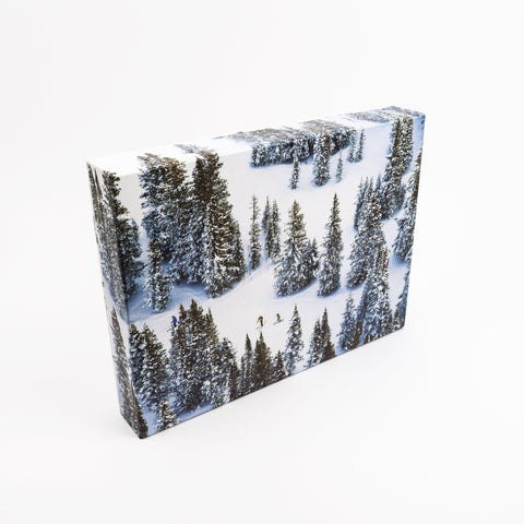 Photo puzzle box of a snowy forest landscape with a person skiing.