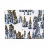 Jigsaw puzzle with skiers descending a snowy slope with trees on a white background