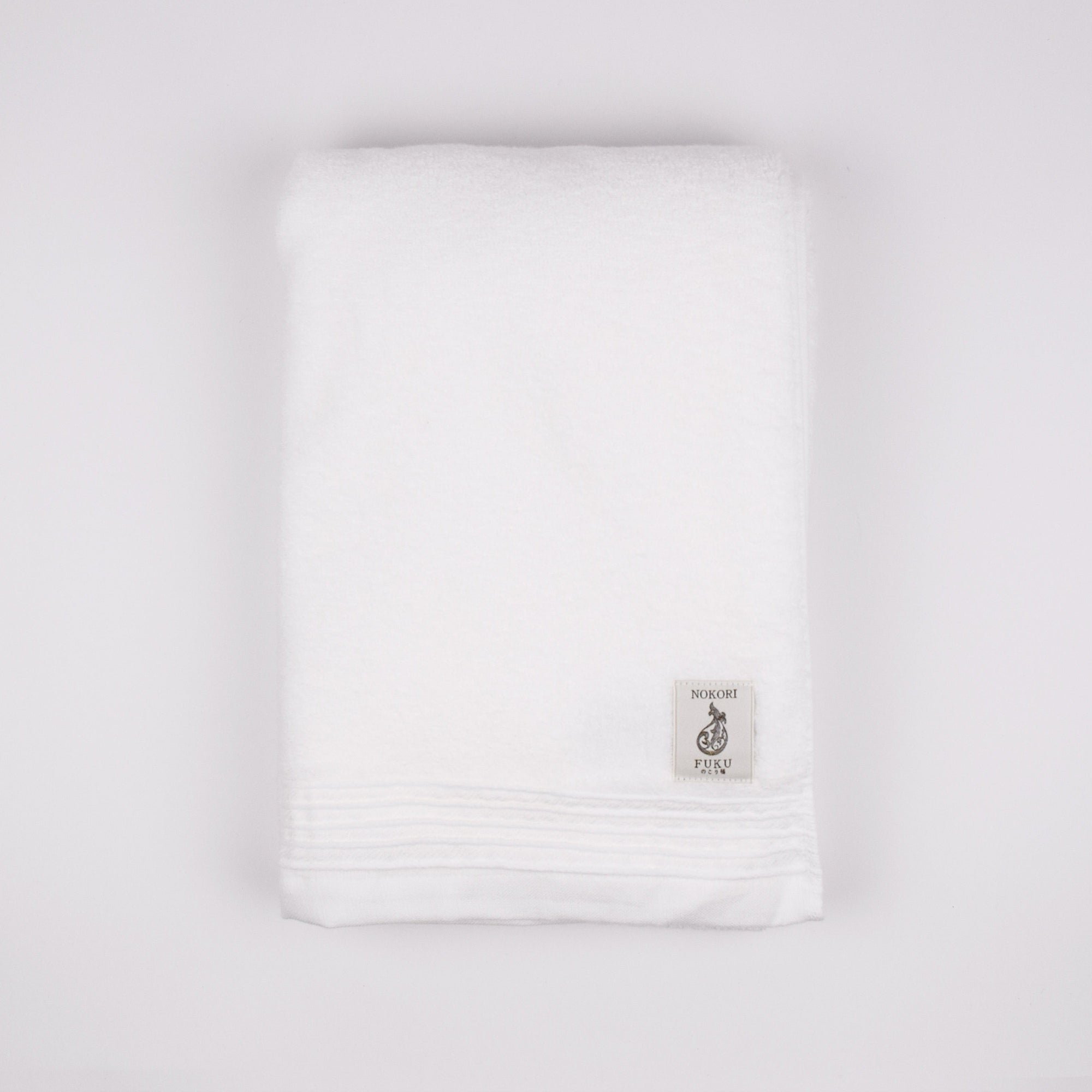 White towel with a small logo on a light gray background