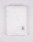 White towel with a small logo on a light gray background