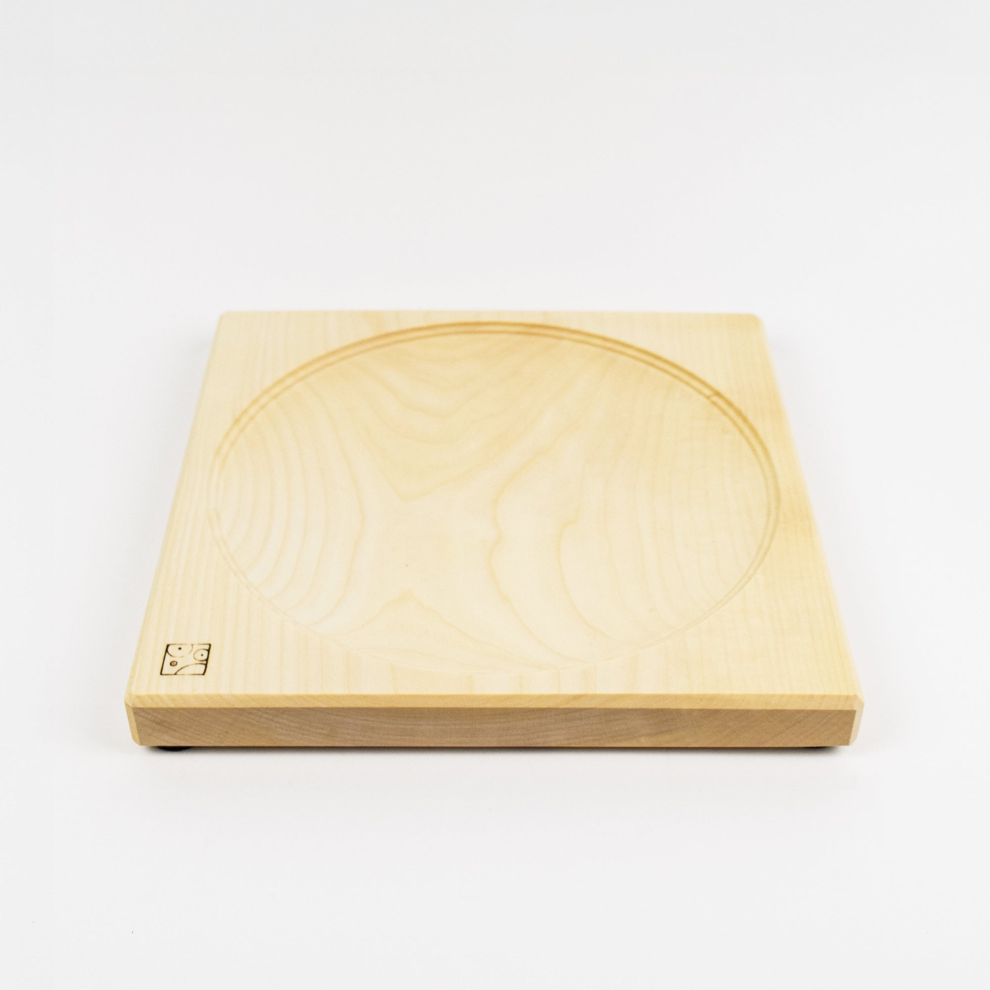Wooden square top spinning plate with circular groove on a white background