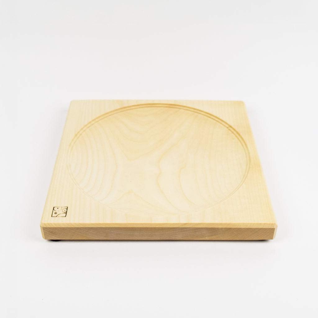 Wooden square top spinning plate with circular groove on a white background