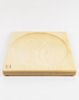 Wooden square top spinning plate with circular groove on a white background