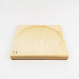 Wooden square top spinning plate with circular groove on a white background