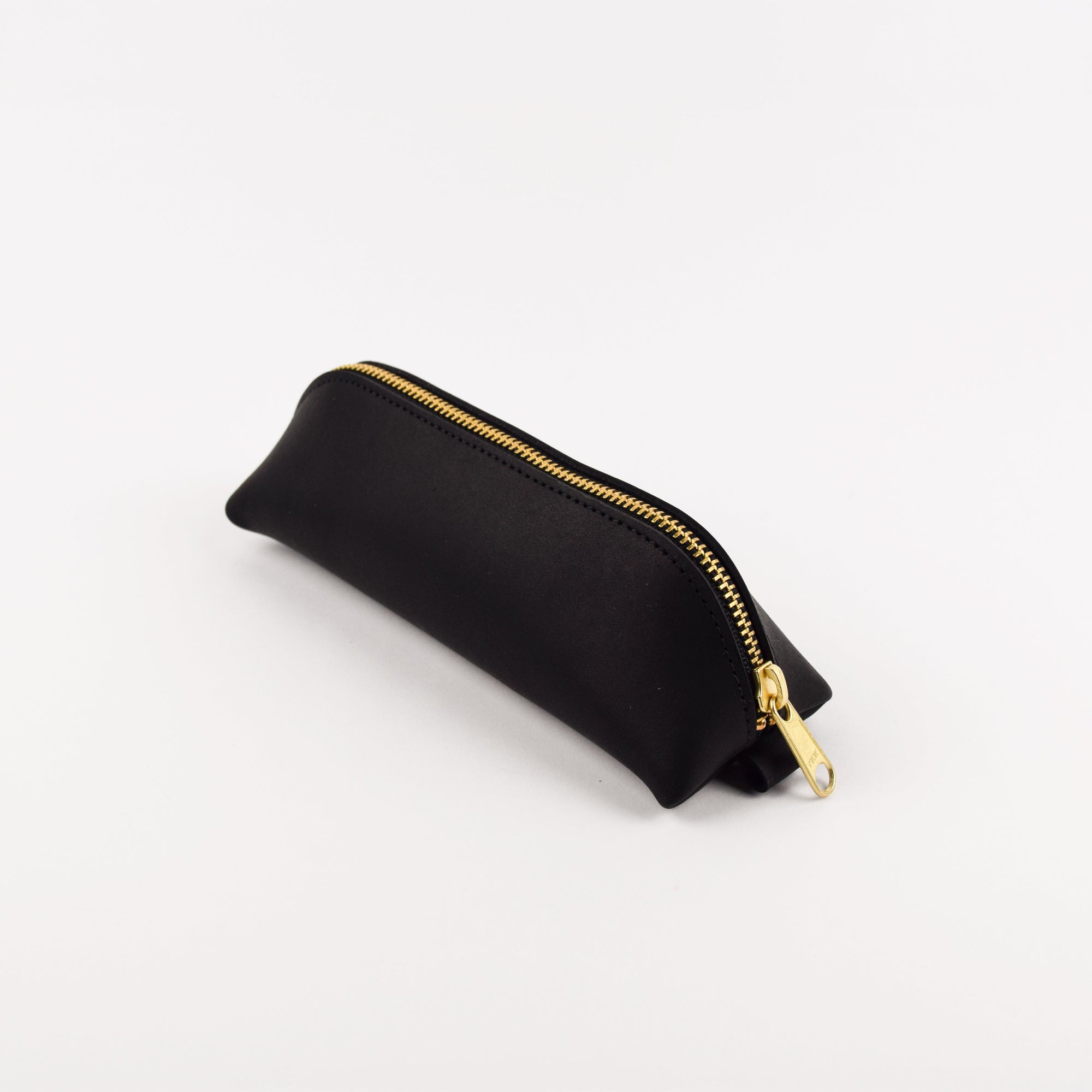 Black pouch with a gold zipper on a white background