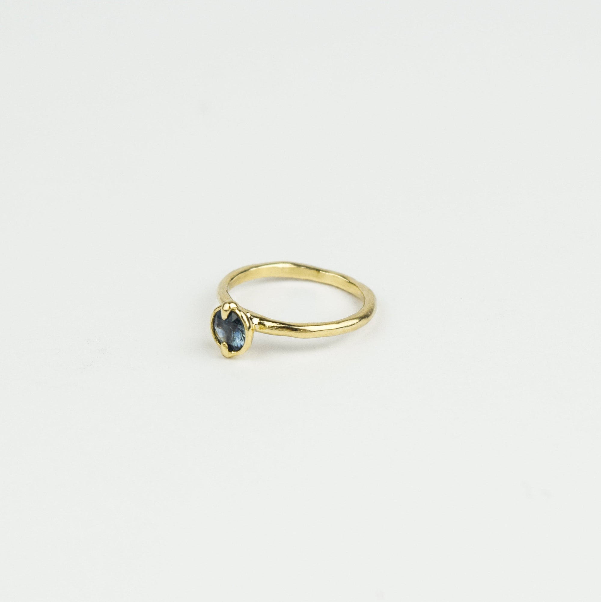 Gold ring with a gemstone on a light gray background