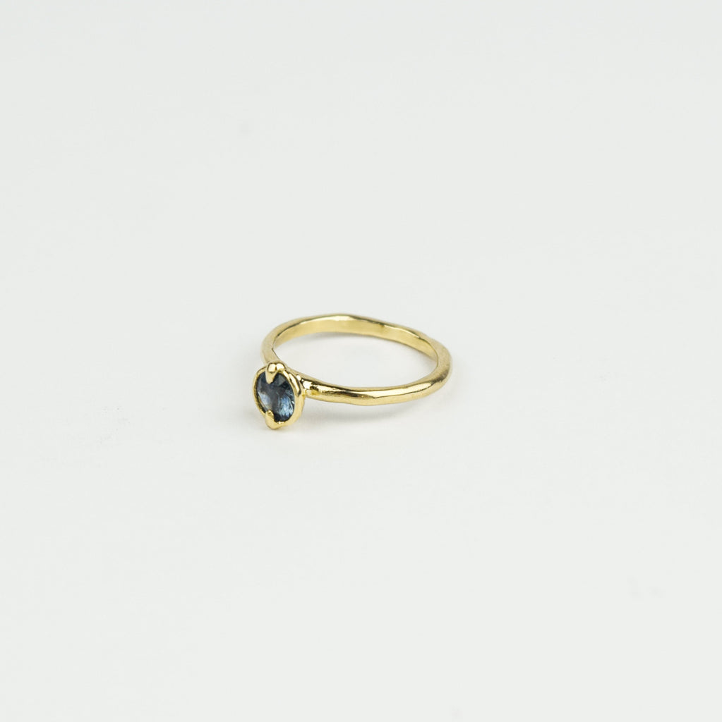 Gold ring with a gemstone on a light gray background