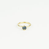 Gold ring with a blue gemstone on a white background