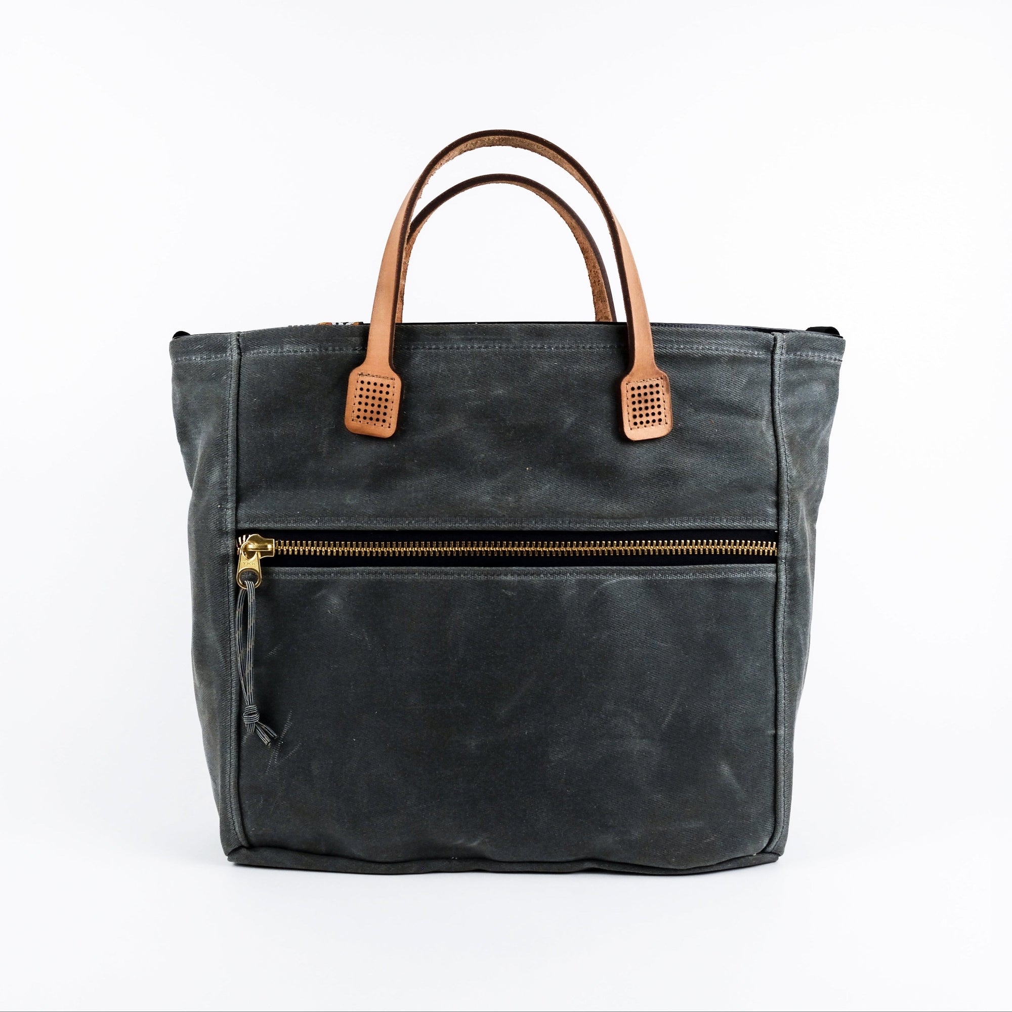 Gray waxed canvas tote bag with tan leather handles on a white background