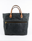 Gray waxed canvas tote bag with tan leather handles on a white background