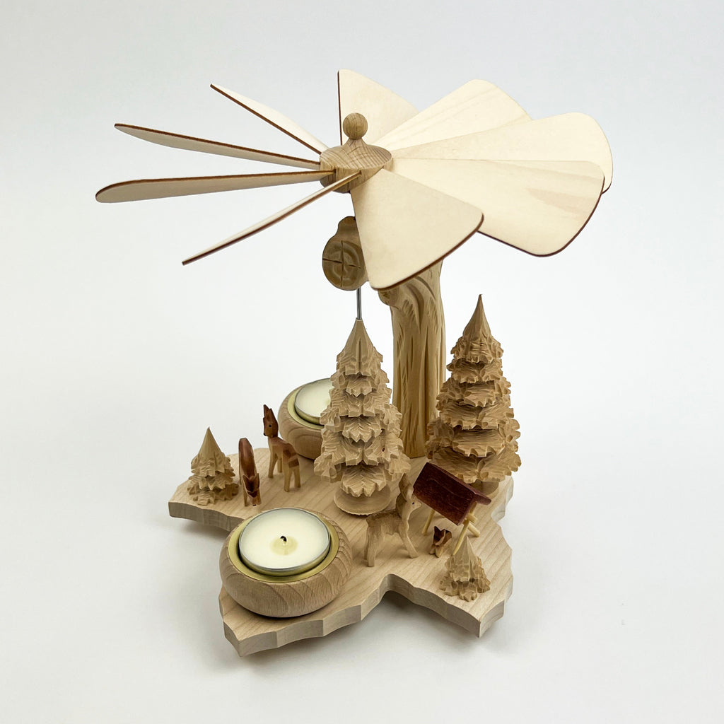 Wooden windmill with a candle on a white background