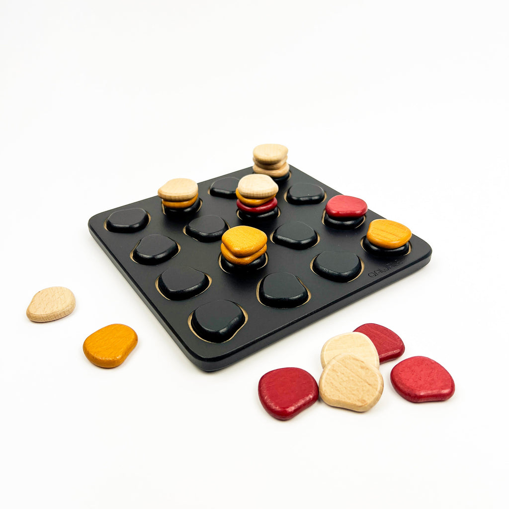 Colorful stone-like game pieces on a black tray with a white background