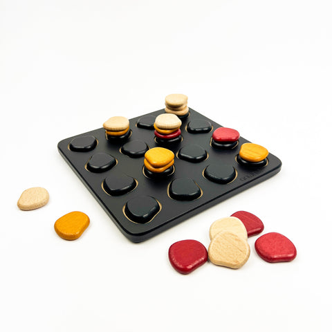 Colorful stone-like game pieces on a black tray with a white background