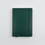 Green notebook on a white surface