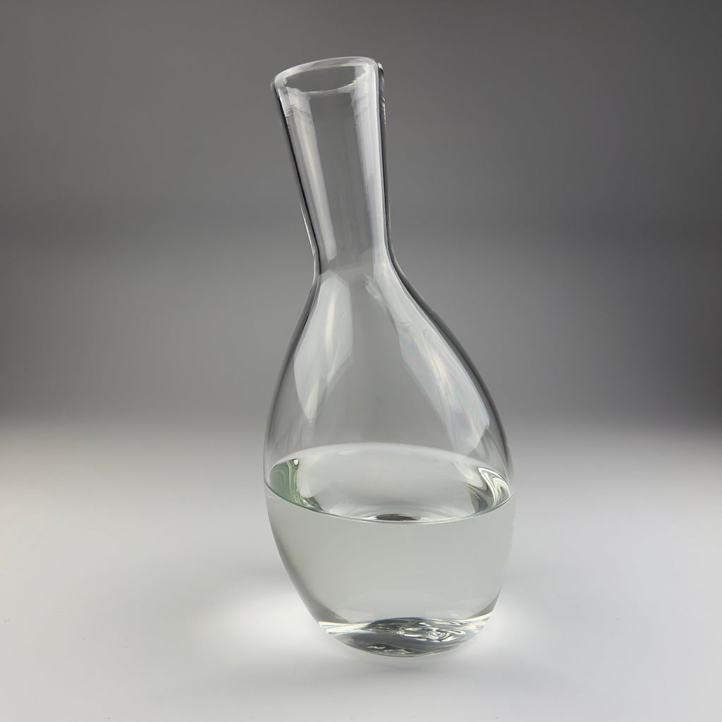 Clear glass carafe on a gray background