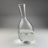 Clear glass carafe on a gray background
