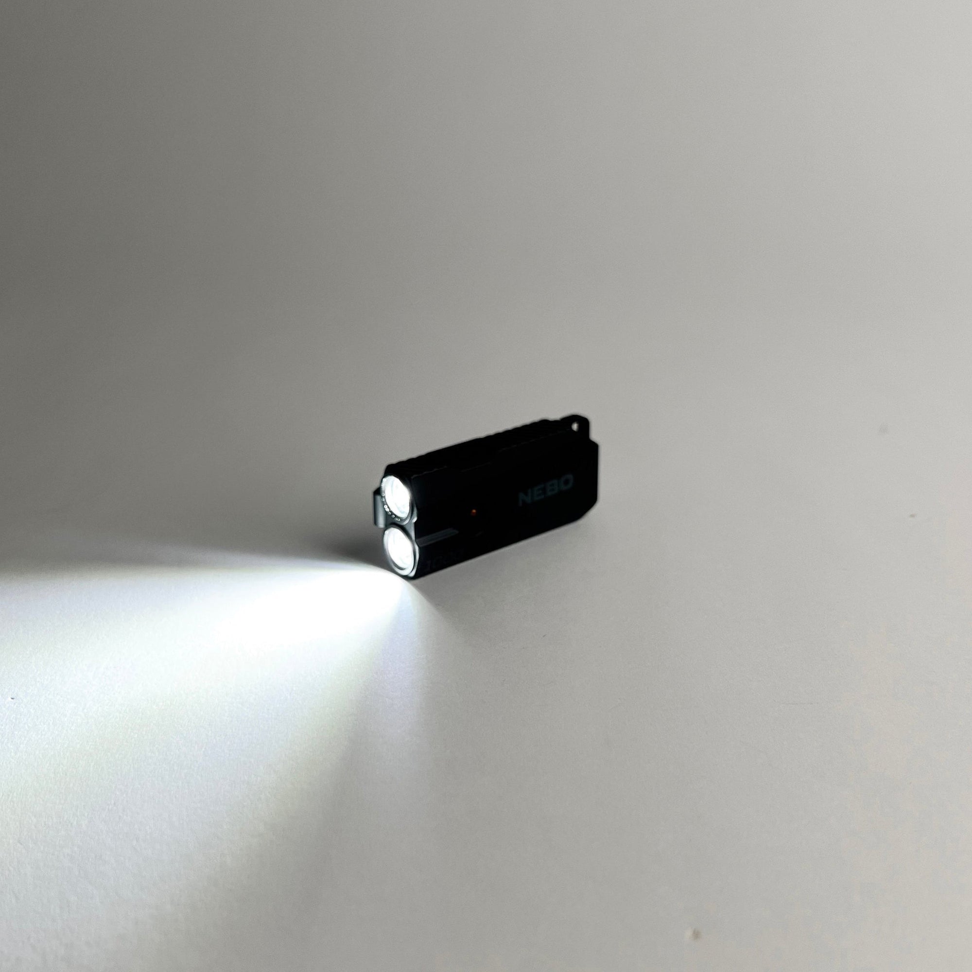 Black flashlight emitting light on a gray background