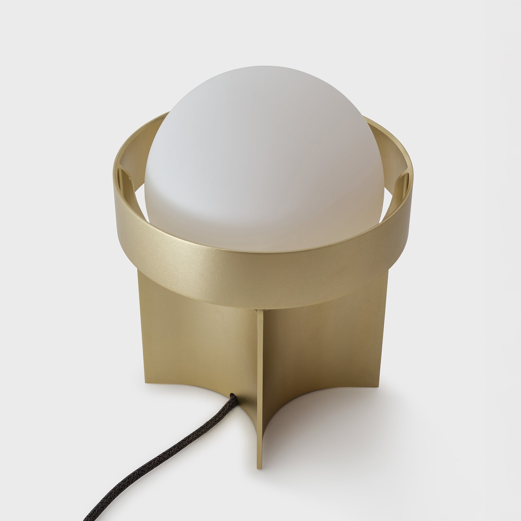 Modern table lamp with a gold base and white shade on a light gray background