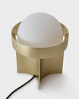 Modern table lamp with a gold base and white shade on a light gray background