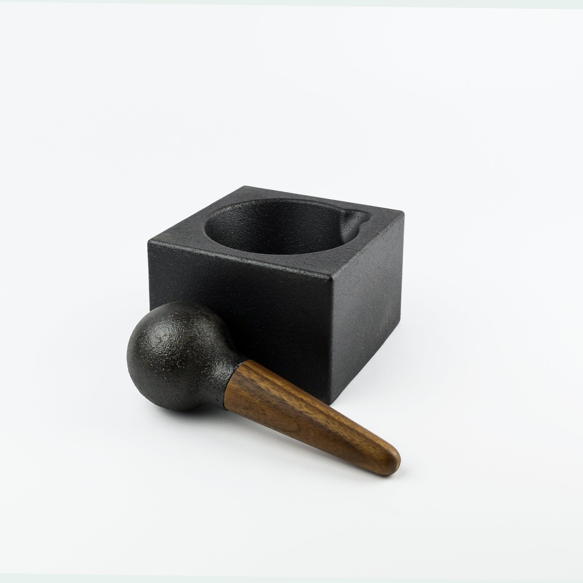 Black square mortar and pestle on a white background