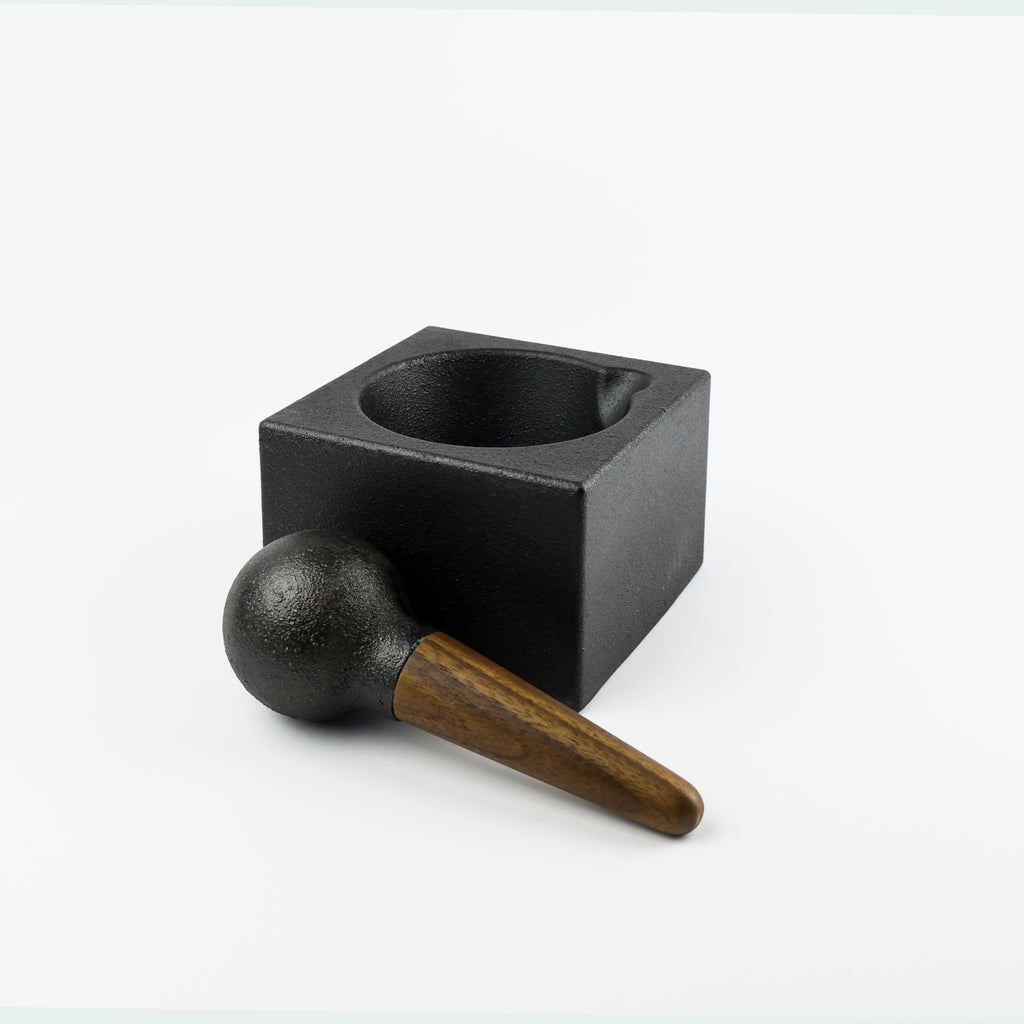Black square mortar and pestle on a white background