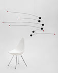 Modern chair with a minimalistic mobile sculpture on a white background