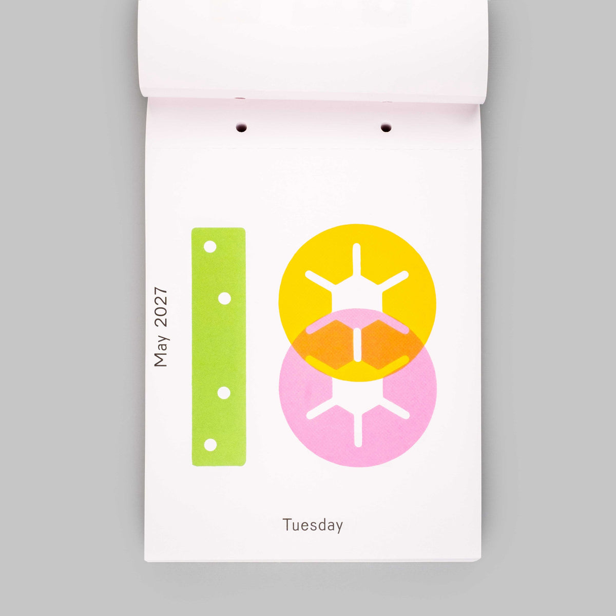 A minimalist weekly calendar page from a white desk calendar, showing May 2027, Tuesday. The page features a clean white background with a lime green vertical bar on the left and overlapping yellow and pink circular sun icons on the right.