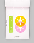 A minimalist weekly calendar page from a white desk calendar, showing May 2027, Tuesday. The page features a clean white background with a lime green vertical bar on the left and overlapping yellow and pink circular sun icons on the right.