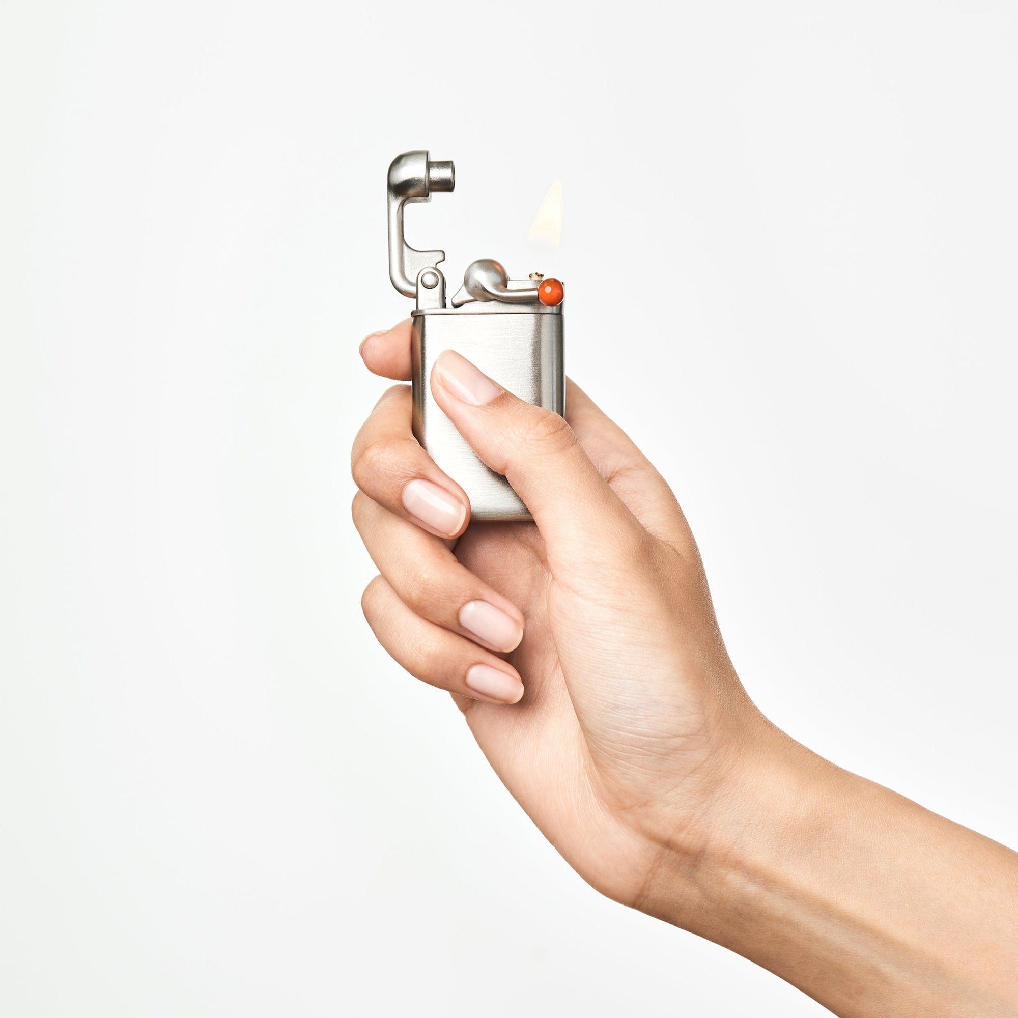 Hand holding a lighter with a flame on a white background