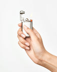 Hand holding a lighter with a flame on a white background