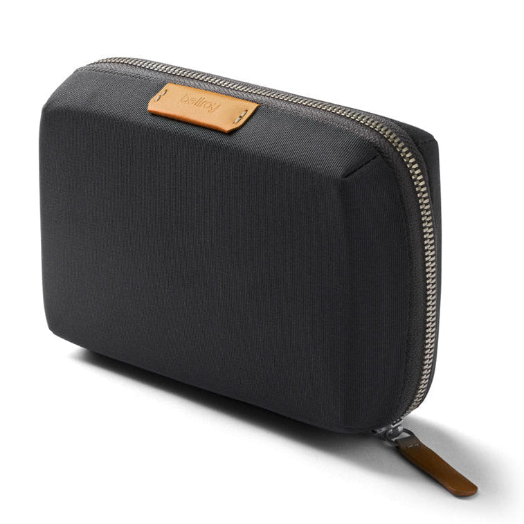 Black zippered pouch with brown leather patch on a white background